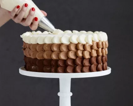 A Cake with a person hand decorating it